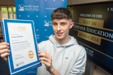 Young male smiles with a certificate