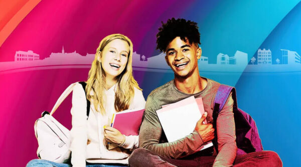 male and female student sitting smiling holding books with colourful background