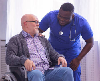 Male nurse helping an elderly man in wheelchair