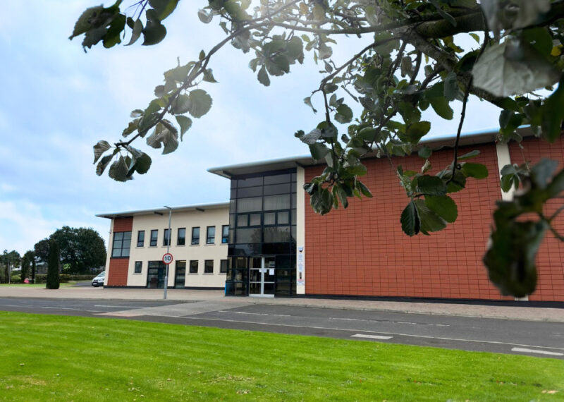 NWRC Greystone exterior campus with leaves in the foreground