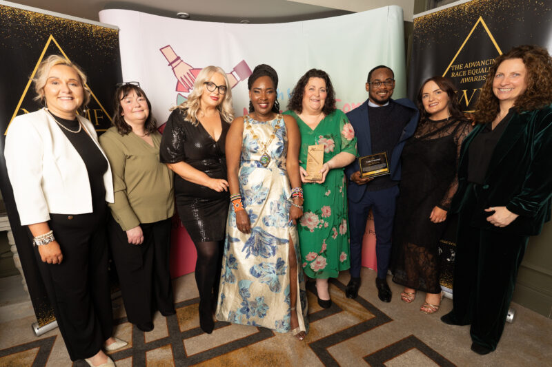 group of women and one man pictured with an award