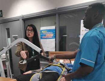 women in a teaching environment explaining nursing techniques to a student n a blue uniform