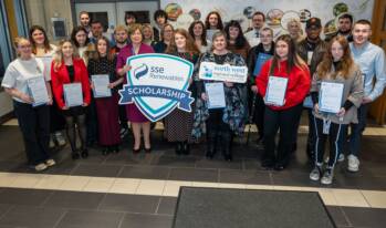 A large group of people smiling - they are holding props for NWRC and SSE renewables.